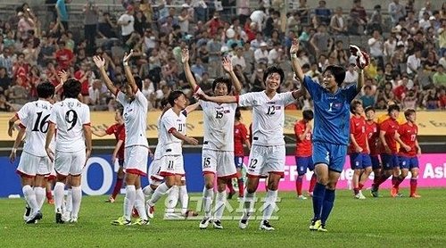 7月21日，“2013东亚杯”女足比赛韩国与朝鲜的比赛在首尔世界杯竞技场举行，图为朝鲜女足球员在胜利之后，正向观众们挥手致意。  