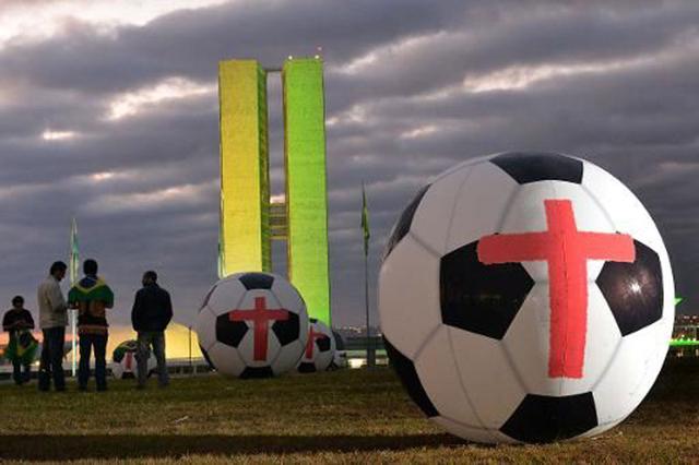 巴西民众国会前放12个巨大足球 抗议世界杯花销